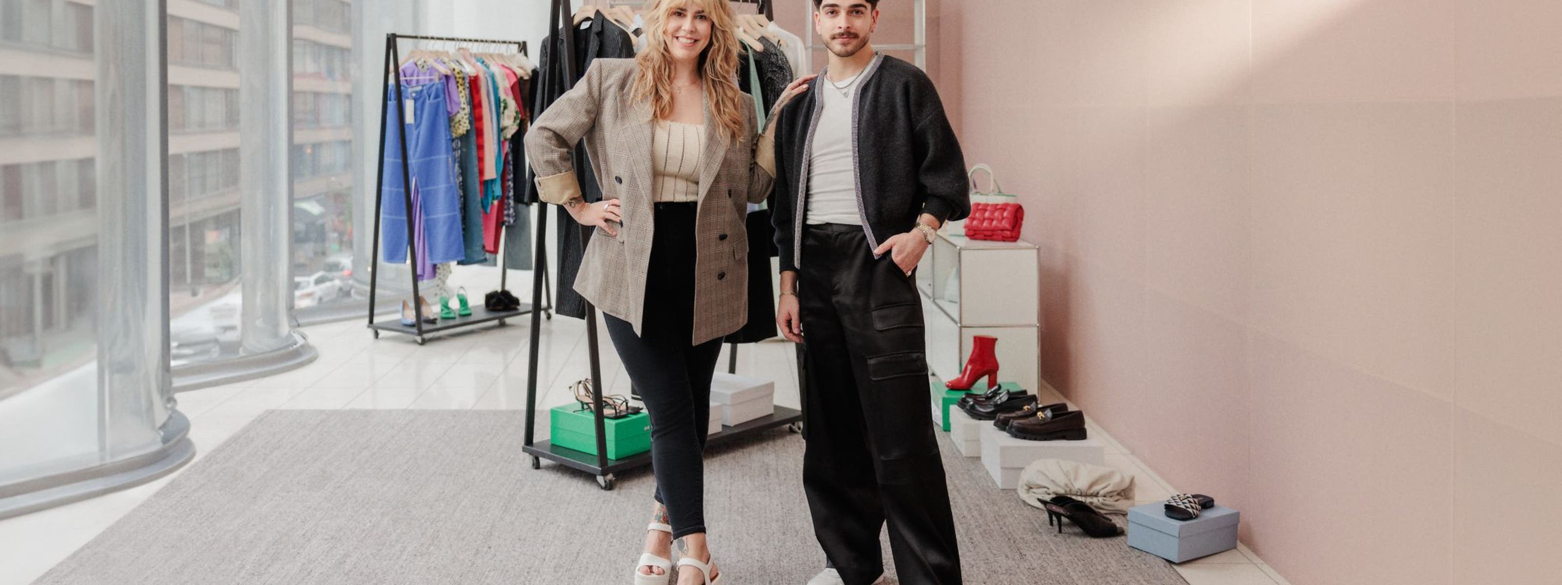 Two Nordstrom stylists in front of racks of clothing, shoes and accessories.