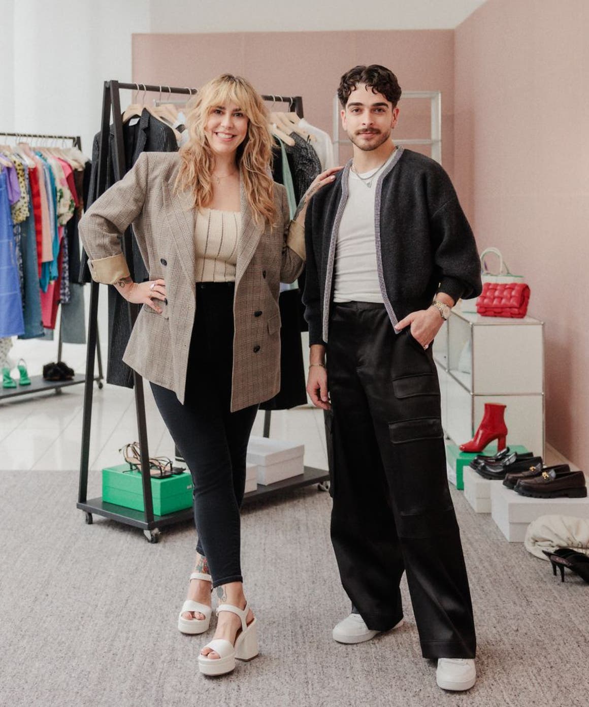 Two Nordstrom stylists in front of racks of clothing, shoes and accessories.