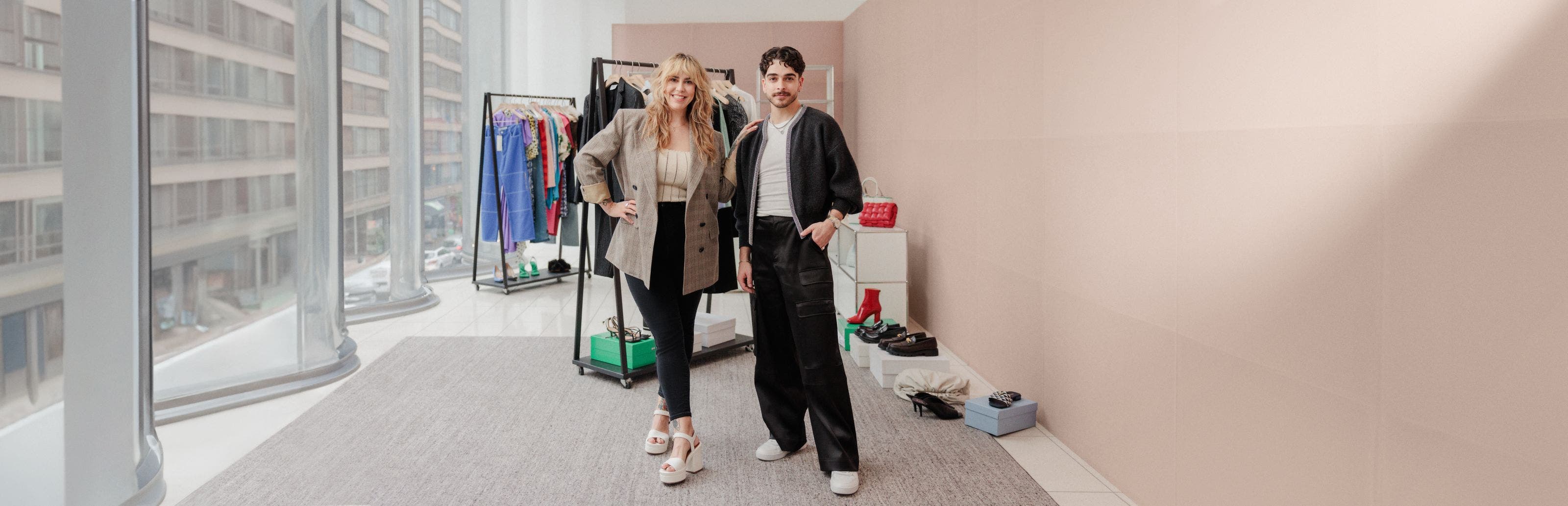A woman and a man standing together in front of racks of clothing, shoes and accessories.