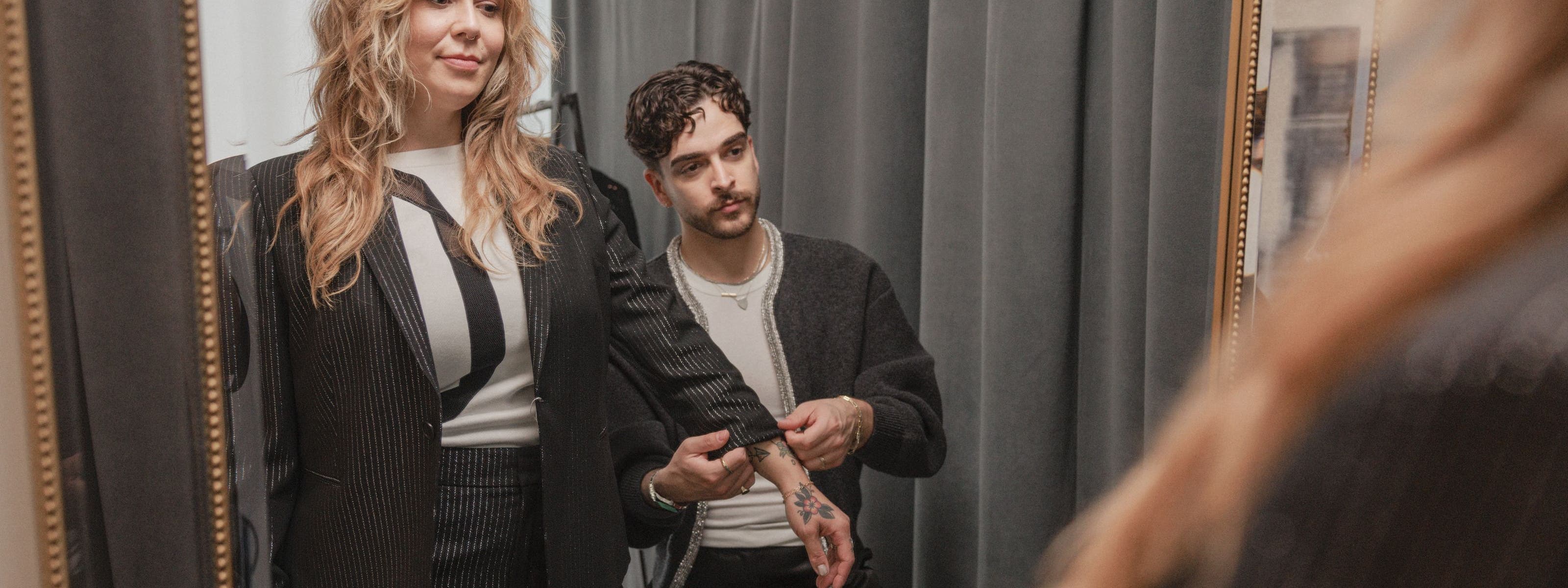 Stylist helping a woman with her sleeve.