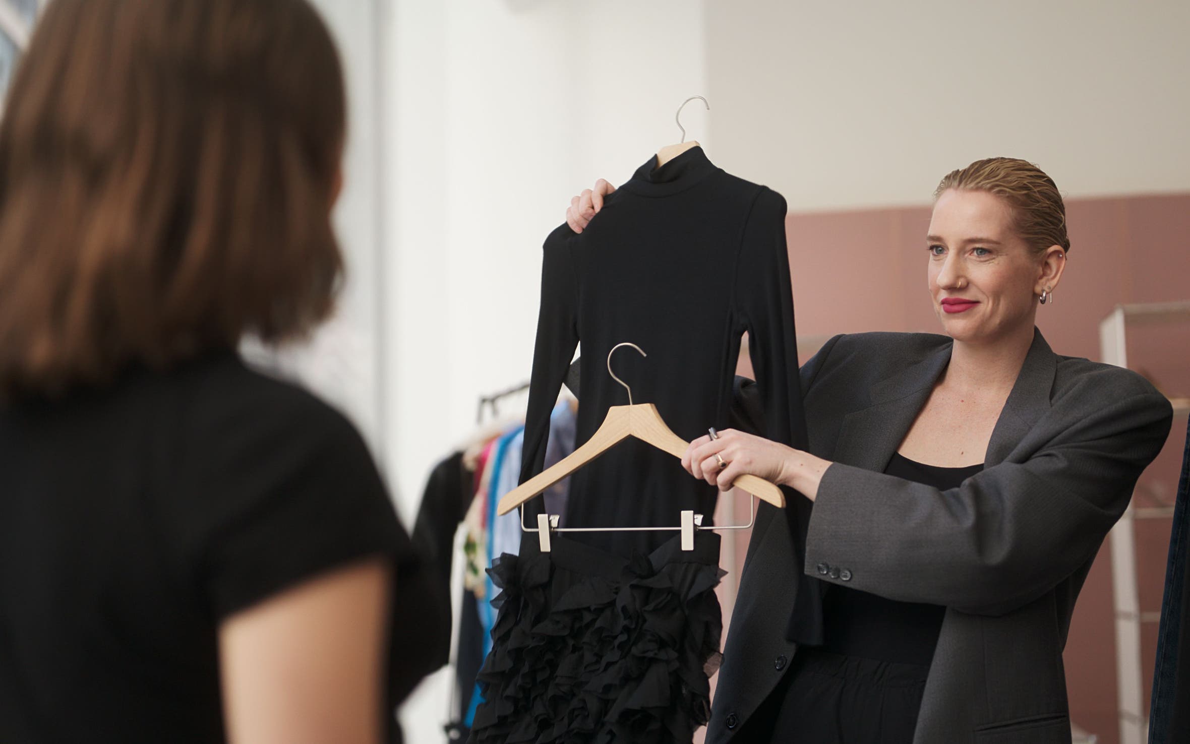 Stylist holding up a black outfit.
