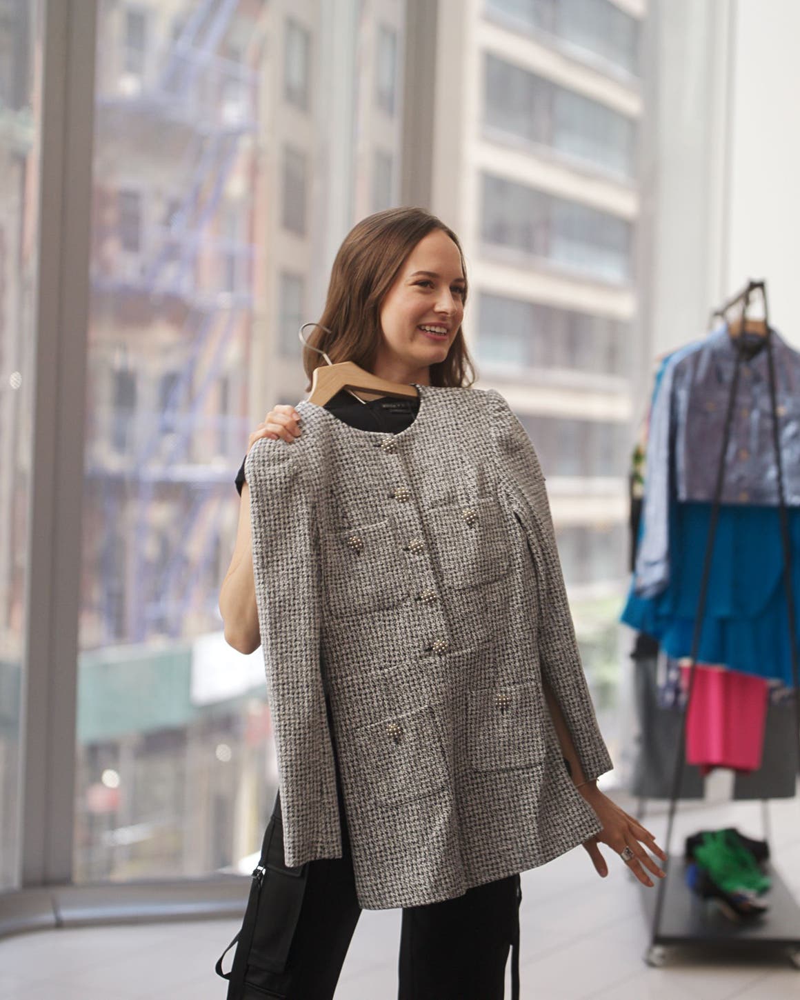 Woman holding up a tweed dress.