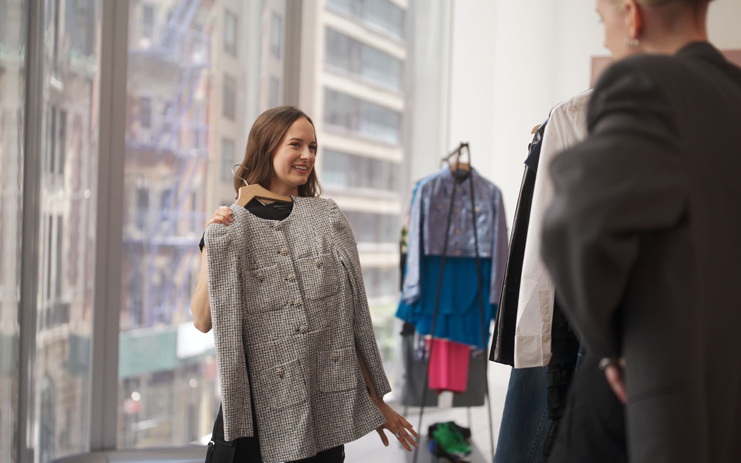 Woman holding up a tweed dress.