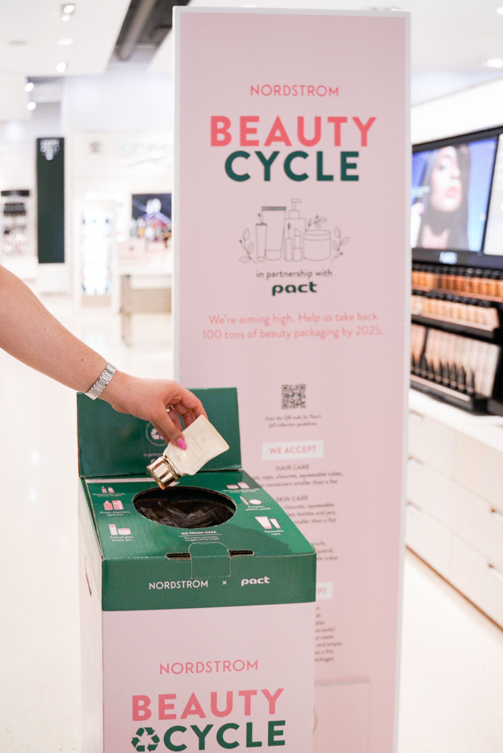 A person putting an empty makeup container into a BEAUTYCYCLE box.