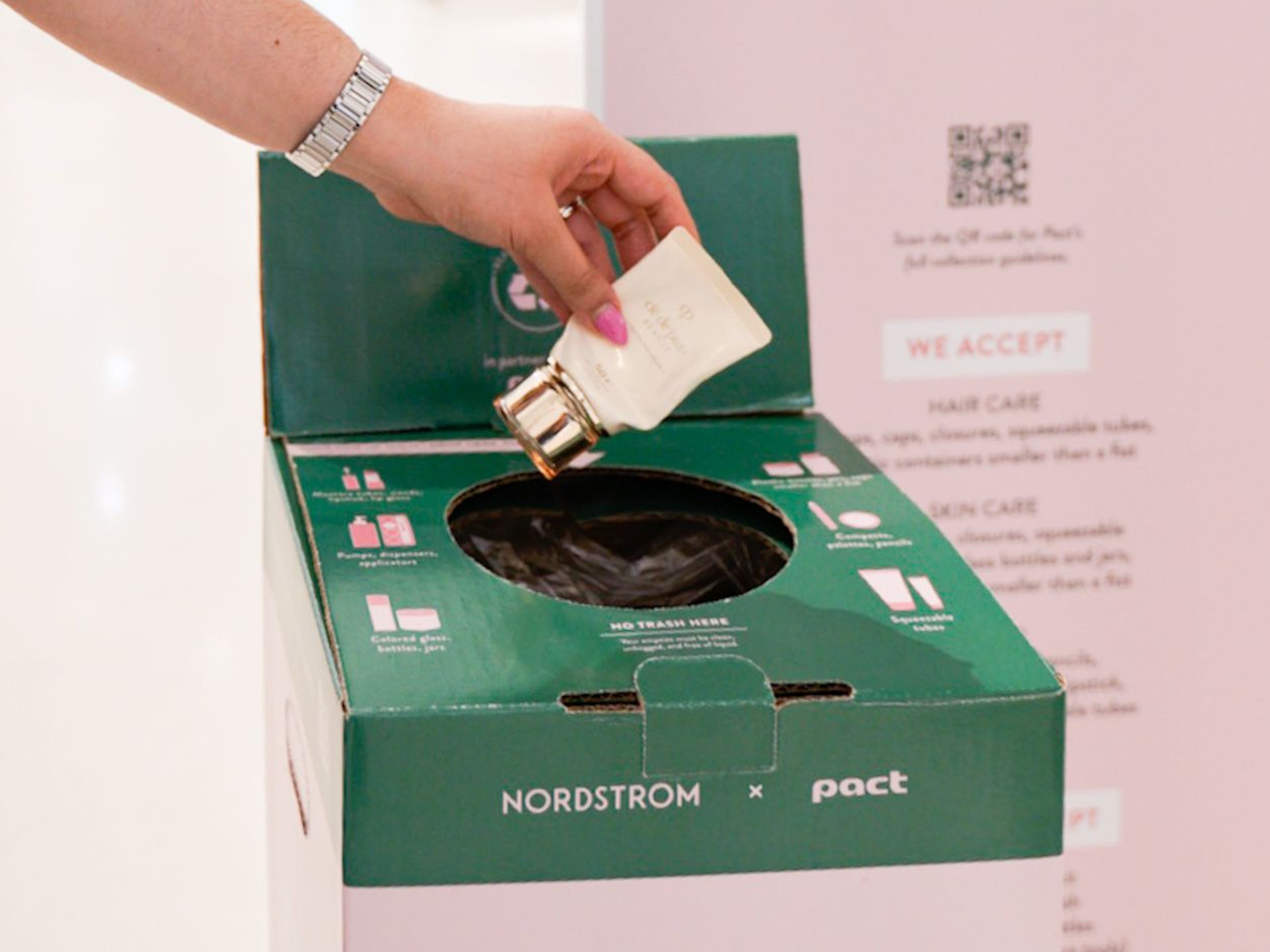 A person putting an empty makeup container into a BEAUTYCYCLE box.