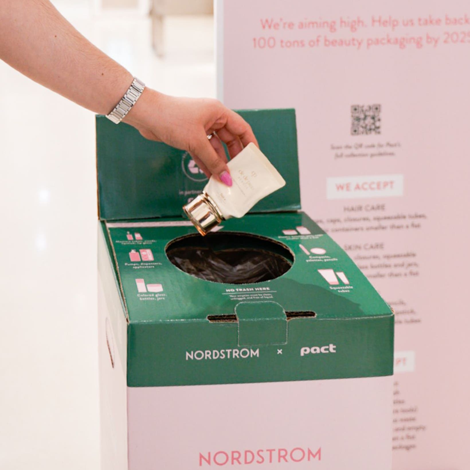A person putting an empty makeup container into a BEAUTYCYCLE box.
