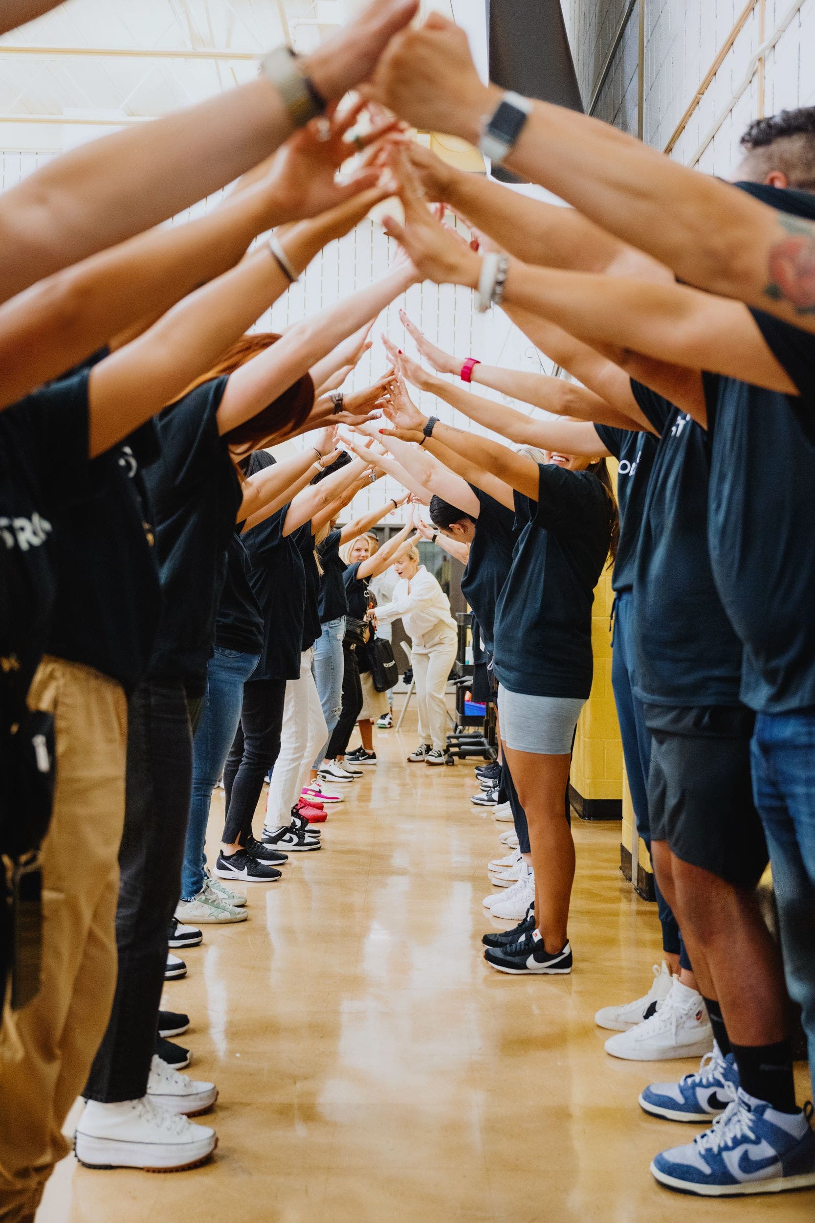 A line of Nordstrom volunteers facing each other and touching fingers.