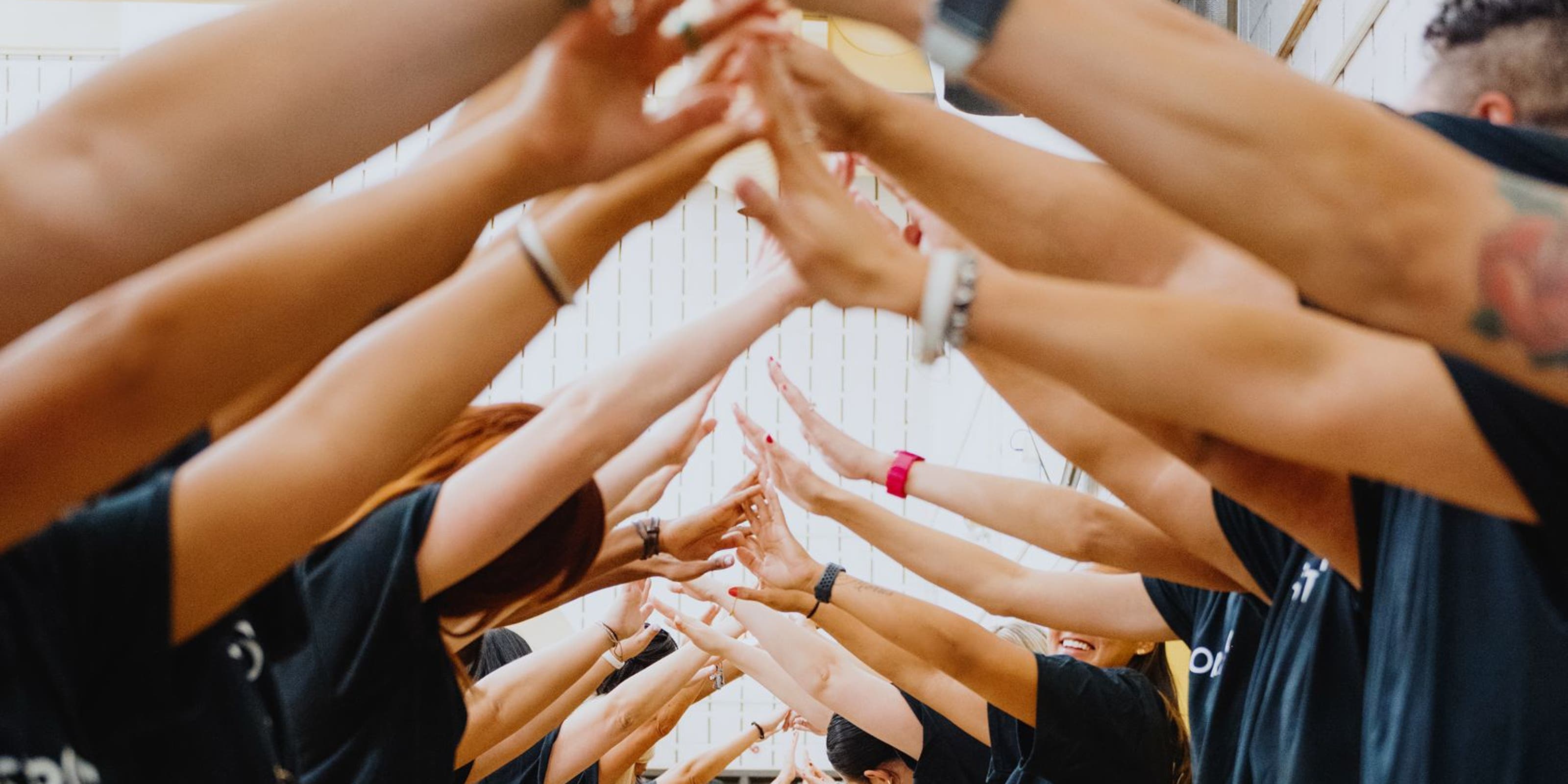 A line of Nordstrom volunteers facing each other and touching fingers.