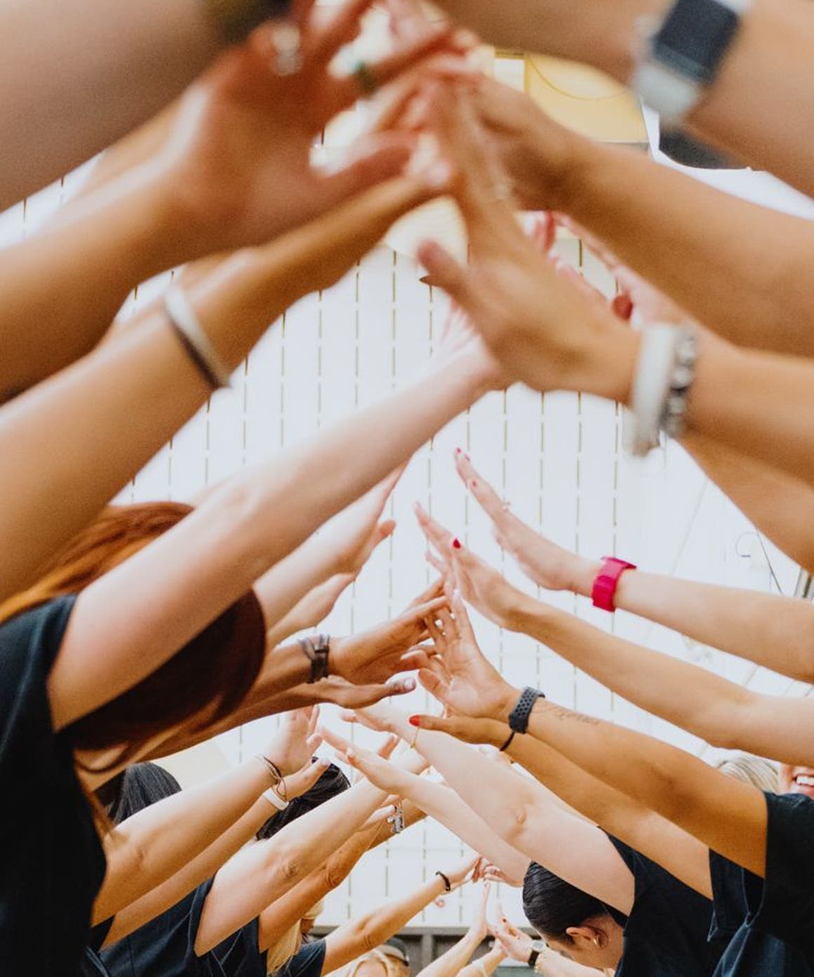 A line of Nordstrom volunteers facing each other and touching fingers.