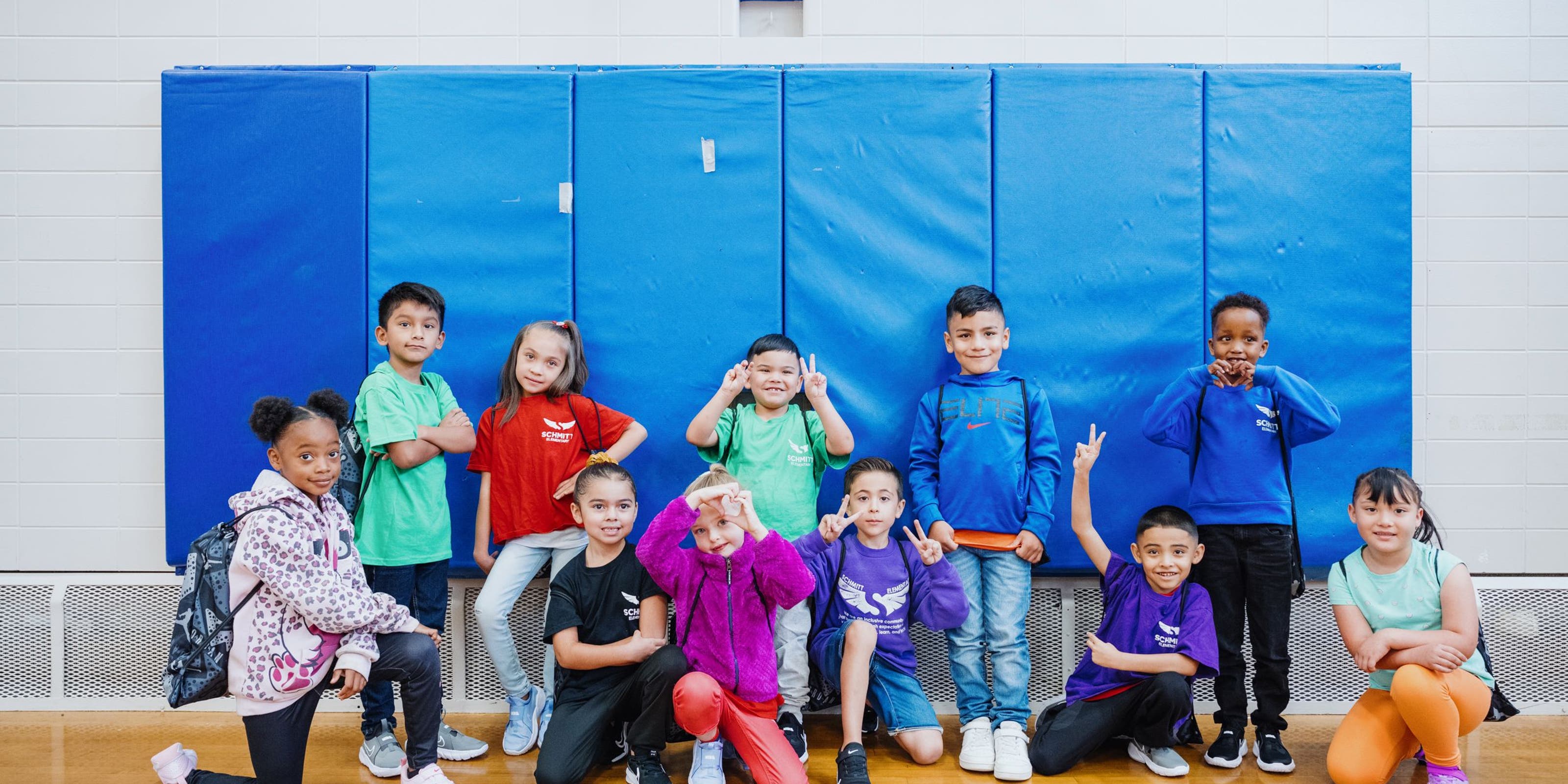 Kids with their new shoes pose for a group photo.