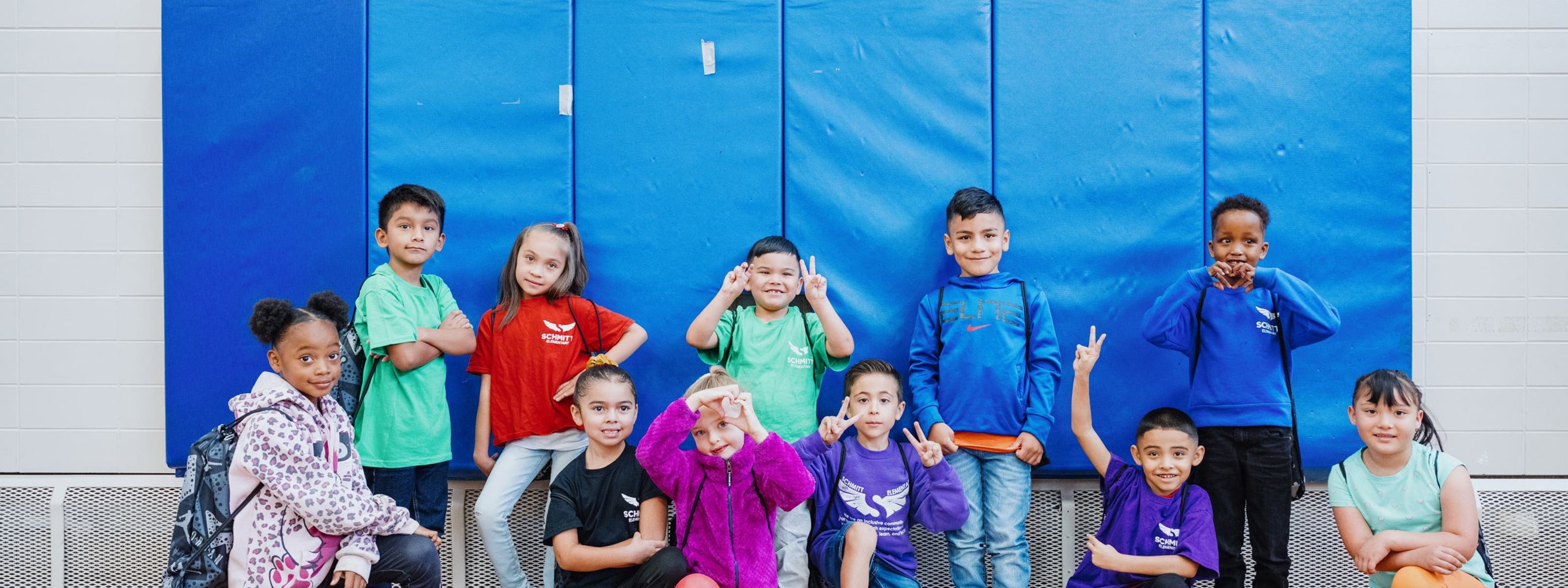 Kids with their new shoes pose for a group photo.