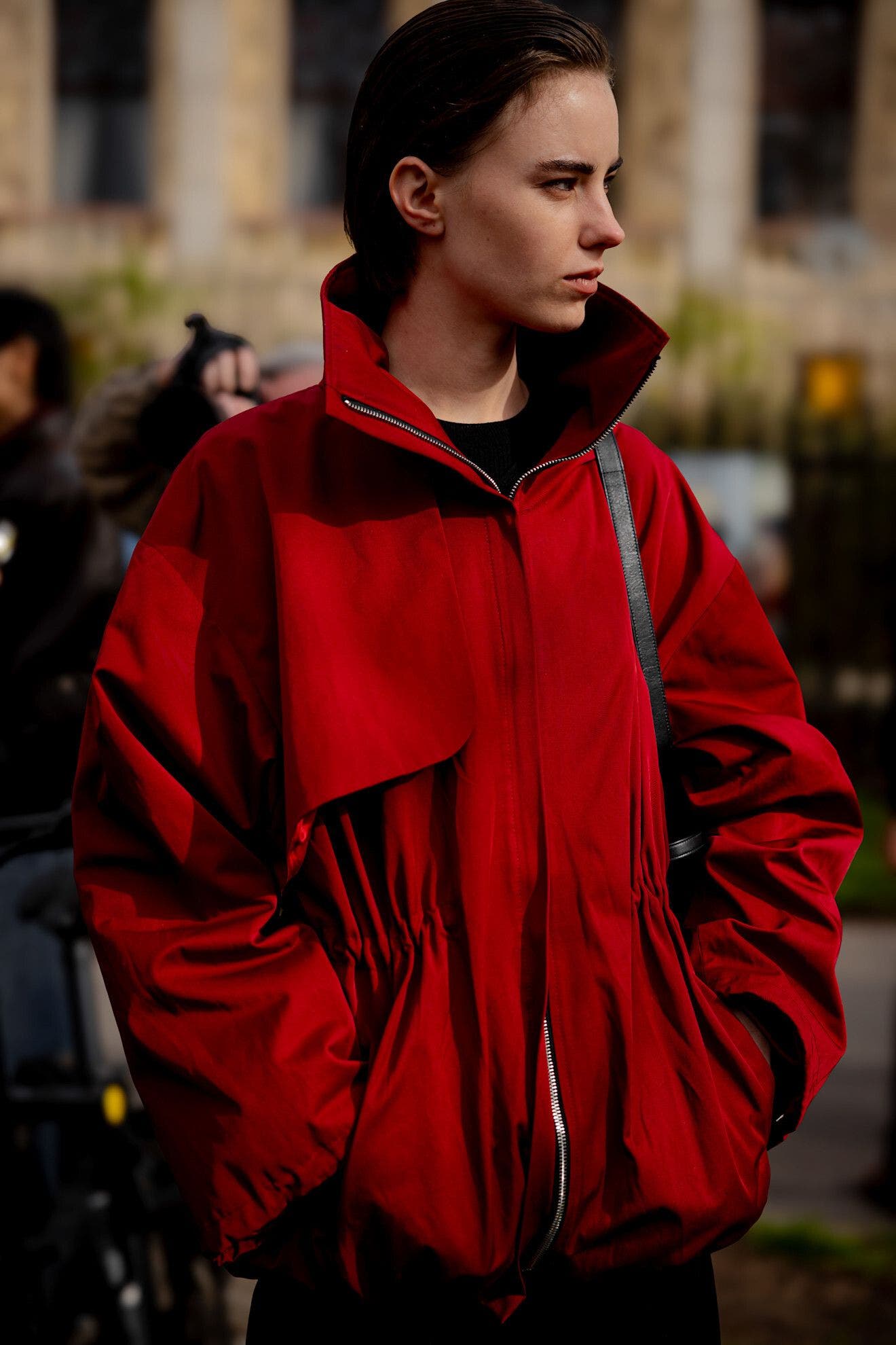 Woman wearing a red jacket at Paris Fashion Week.