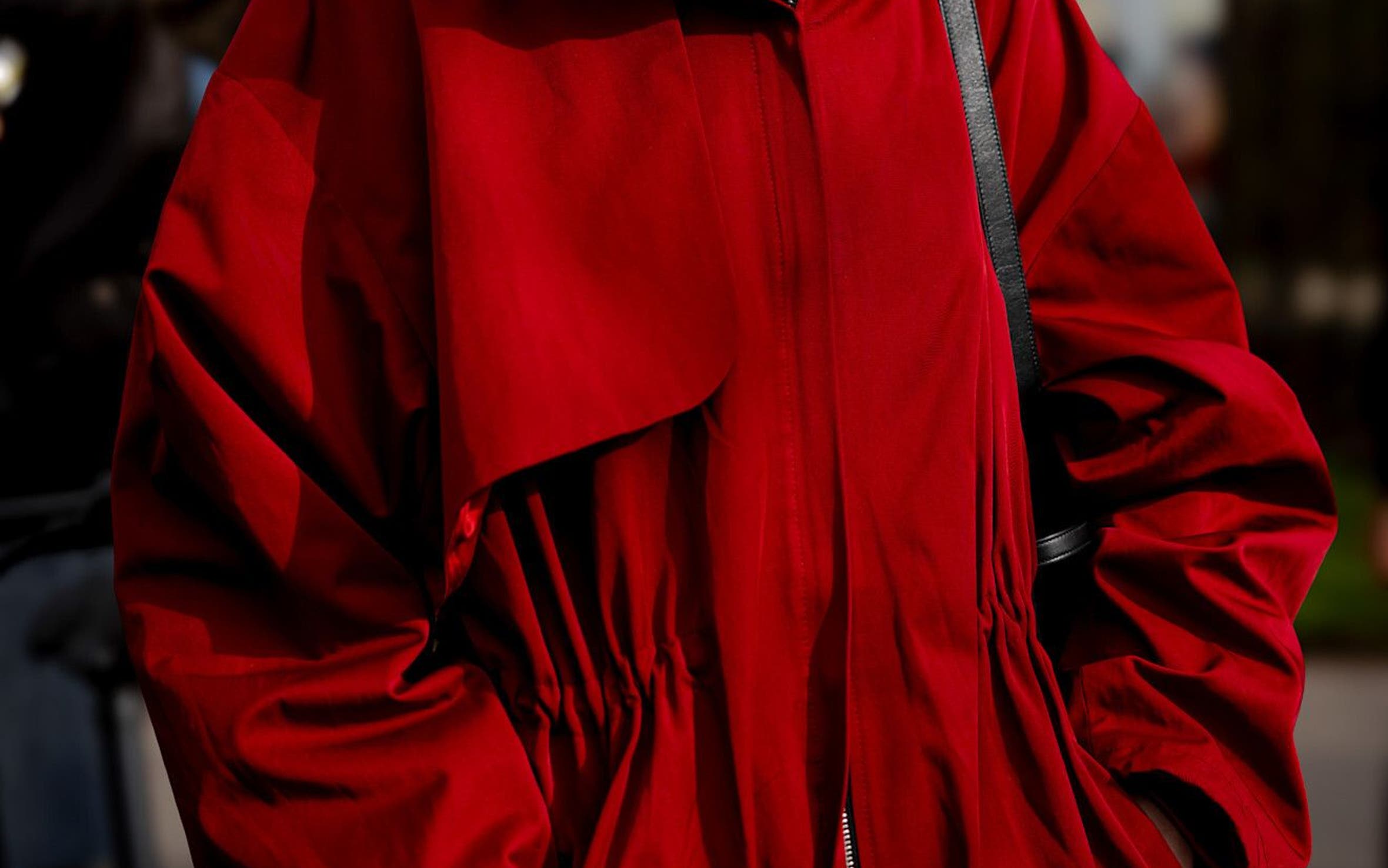 Woman wearing a red jacket at Paris Fashion Week.