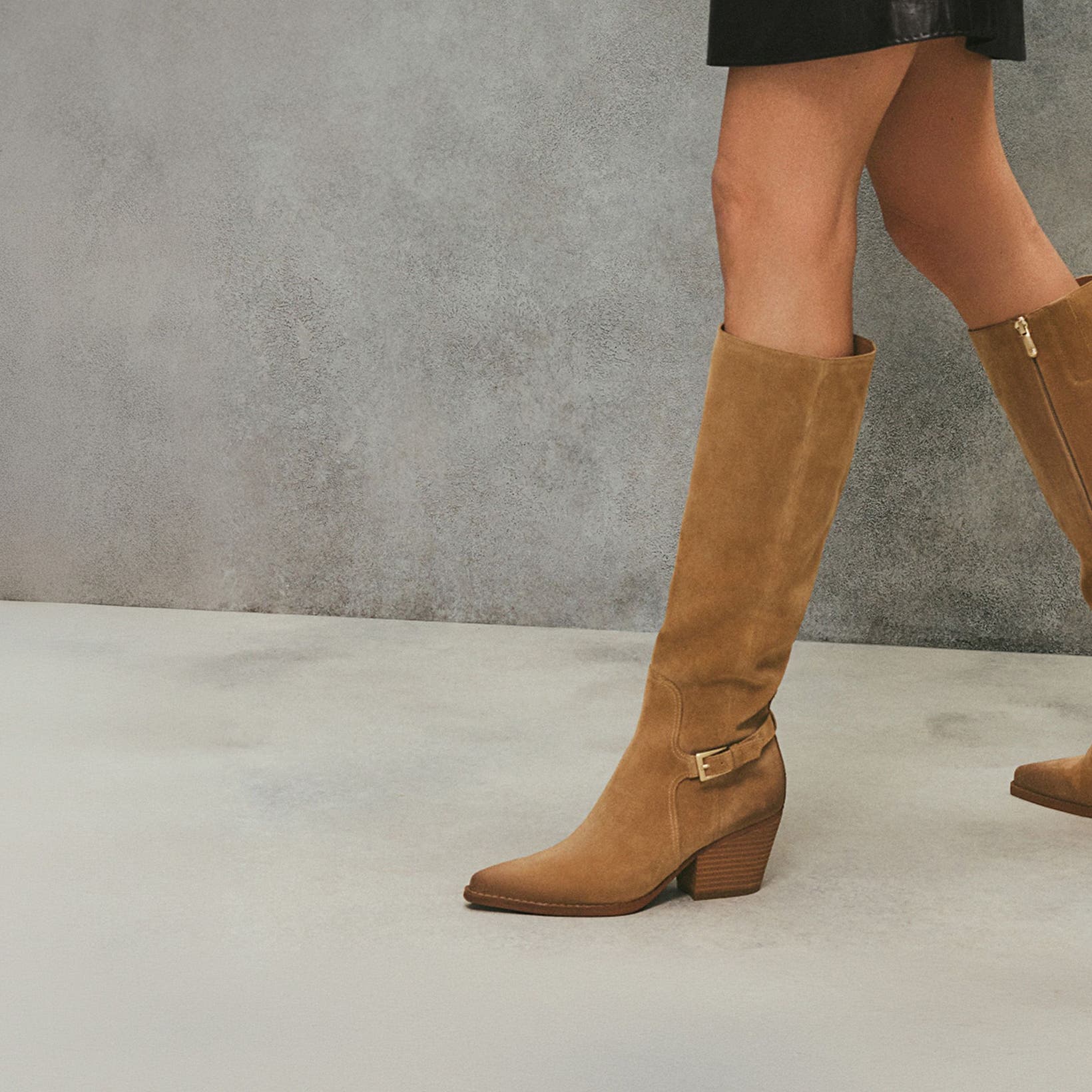 Woman wearing tan knee-high Sam Edelman boots.