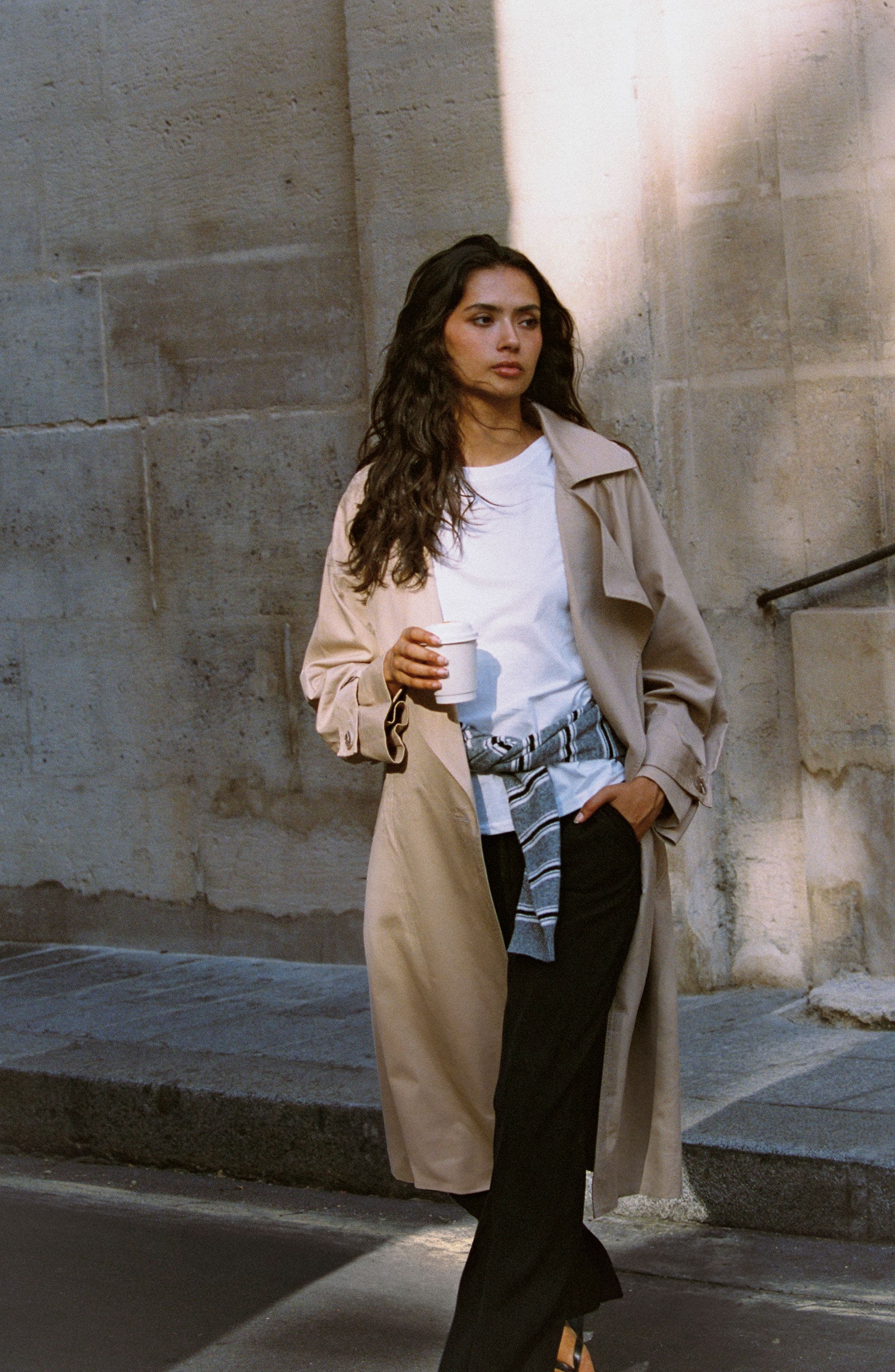 A woman in a beige trench coat.