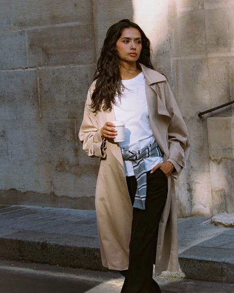 A woman in a beige trench coat.