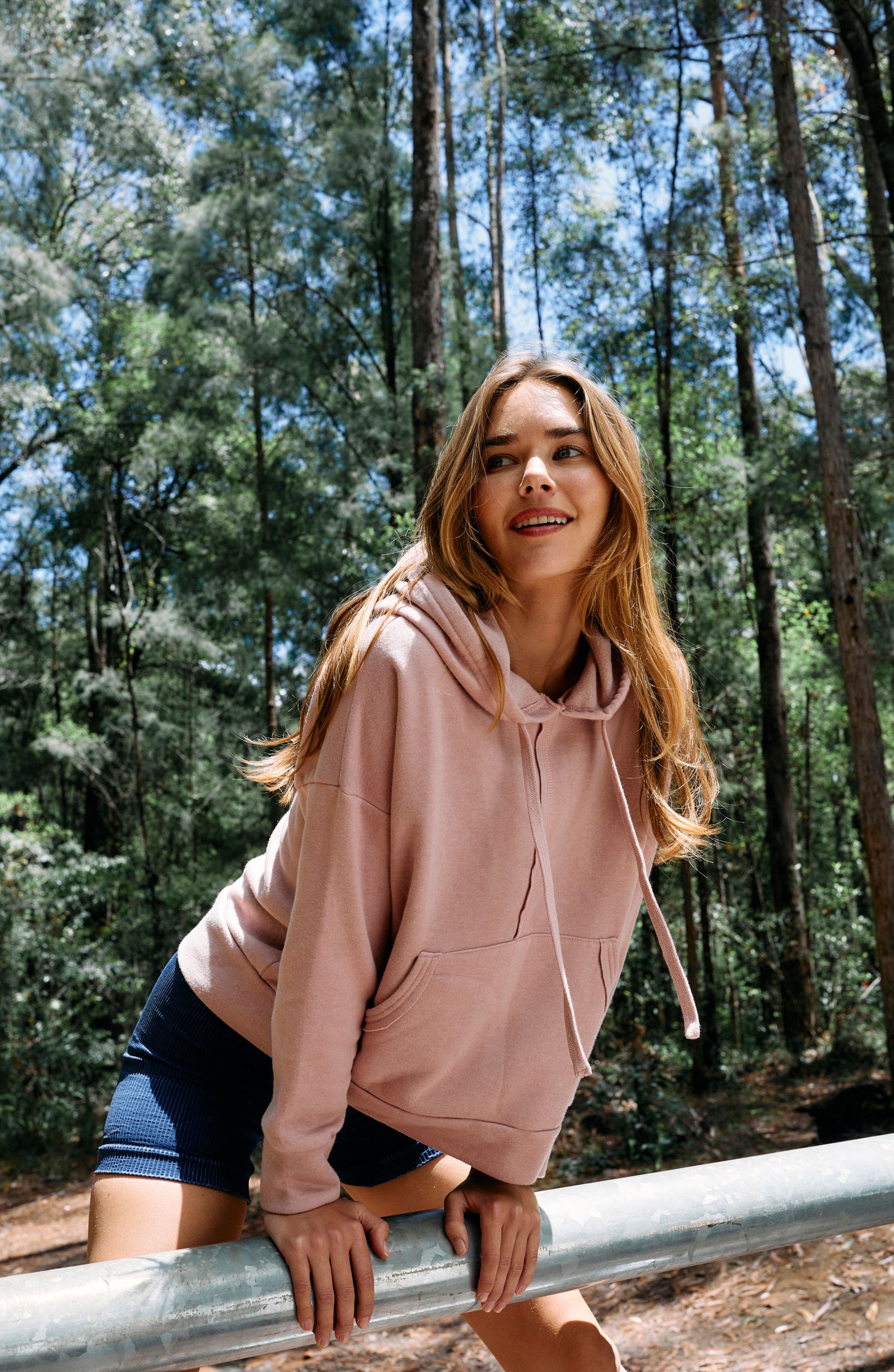 A woman wearing a hoodie and shorts.