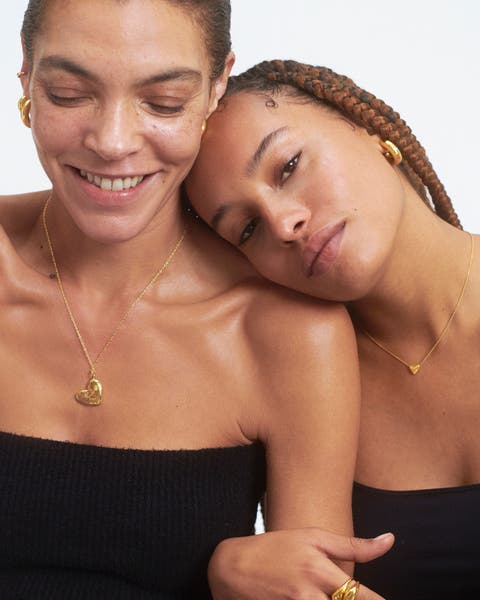 Two women wearing necklaces and earrings 