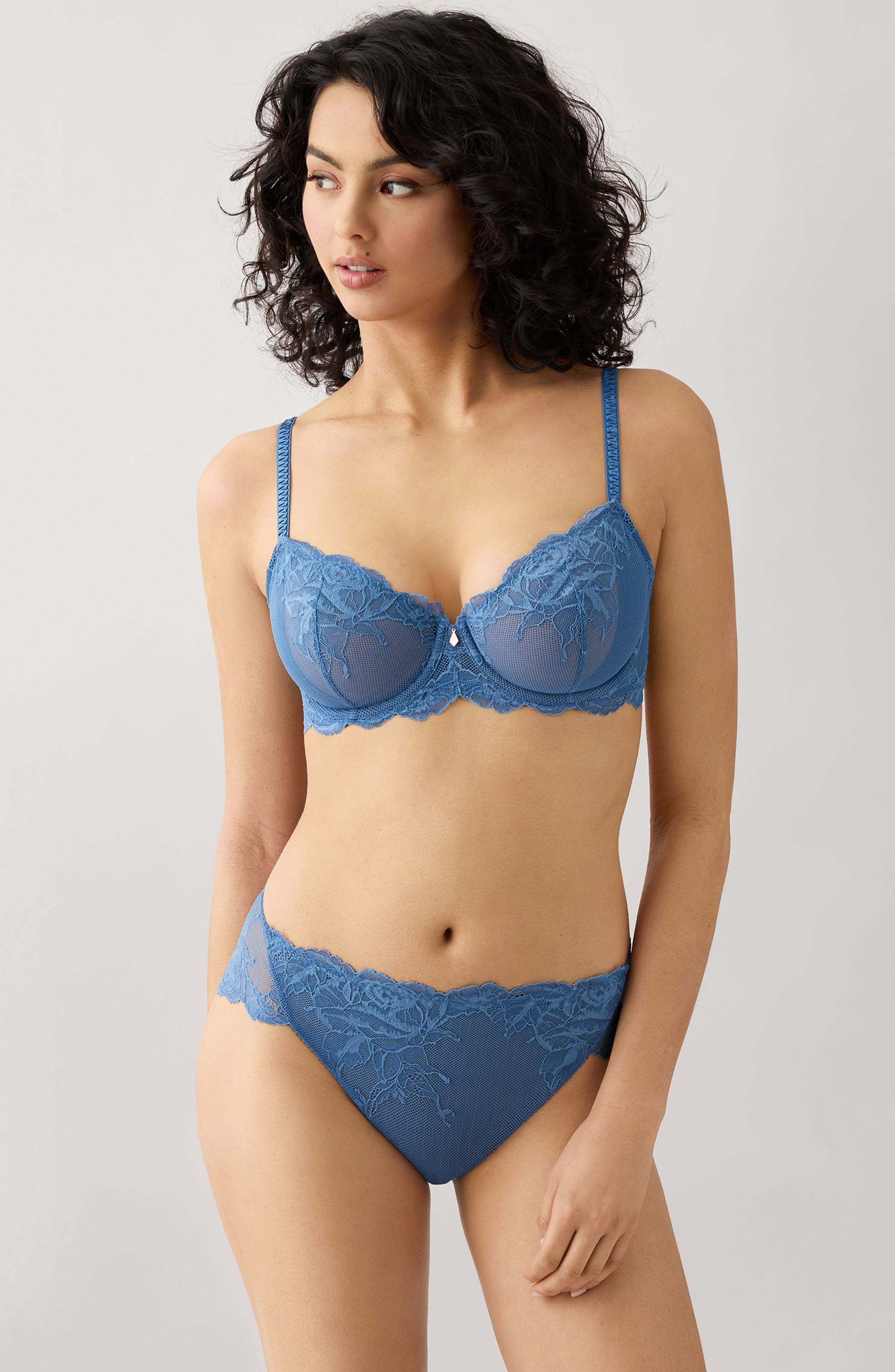 A woman wearing a blue lace underwire bra. 