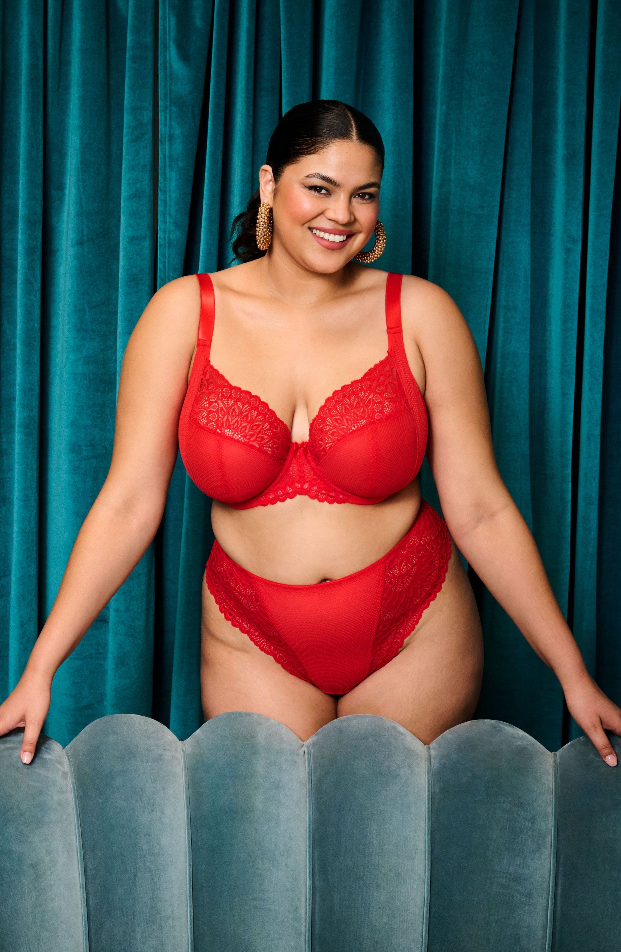 A woman wearing a matching red lace-trimmed bra and panties.