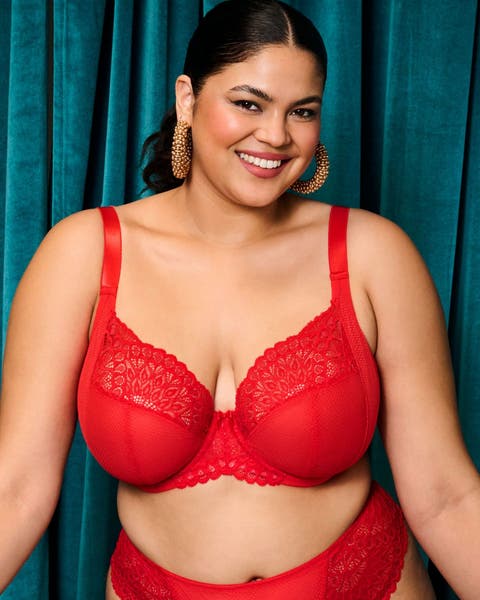 A woman wearing a matching red lace-trimmed bra and panties.