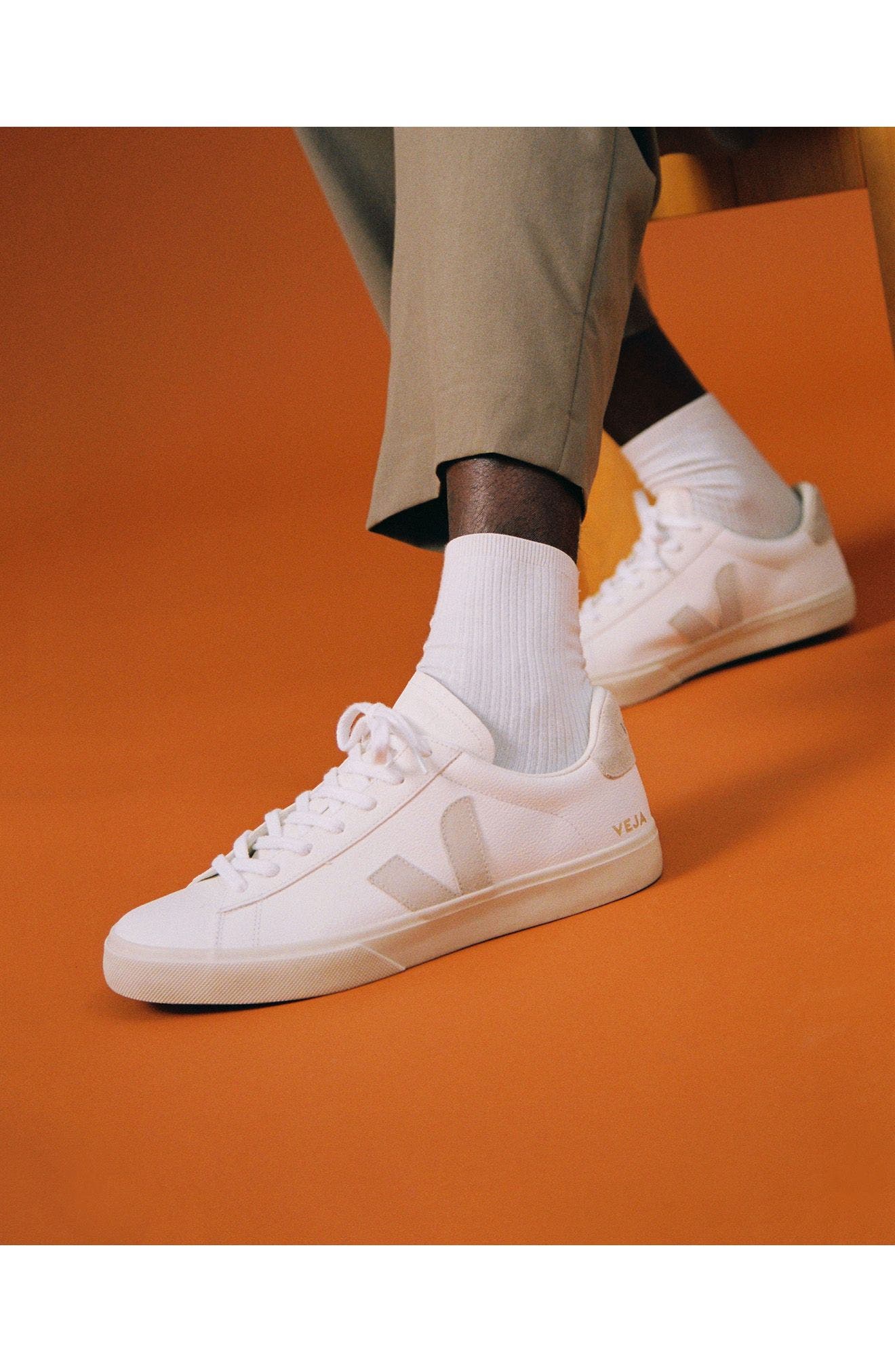A man wearing white sneakers. 