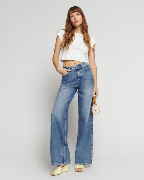 A woman wearing a white tee and jeans.