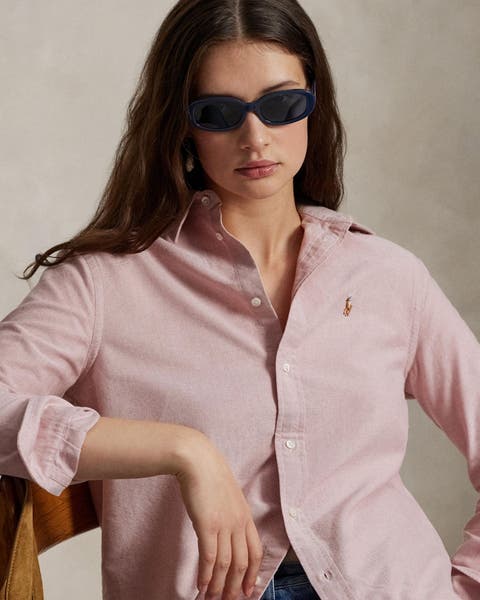 A woman wearing a pink button-up shirt.