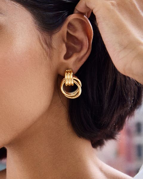 A woman wearing a gold hoop earring.