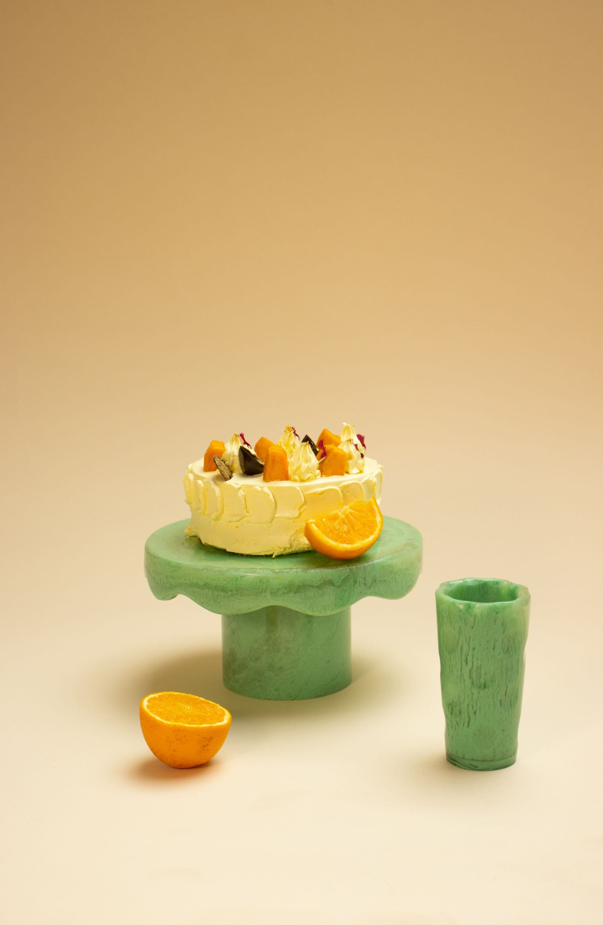 A cake stand with an orange and matching cup.