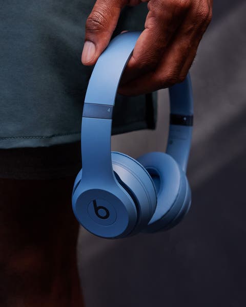 A man holding Beats by Dr. Dre headphones.