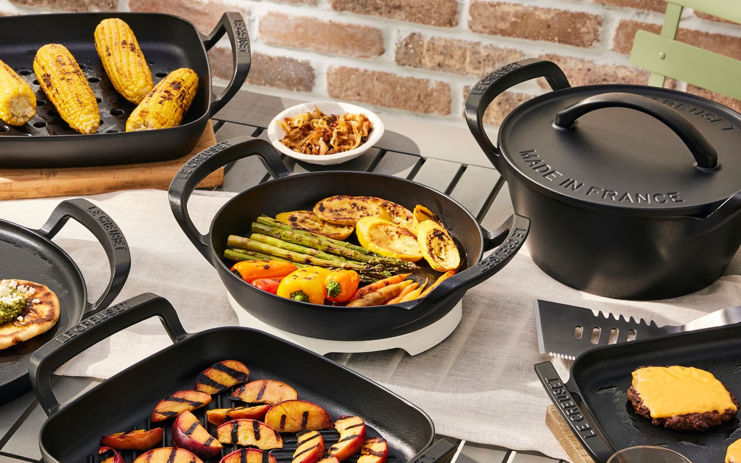 A full spread of grilled foods served on Le Crueset grill pans.