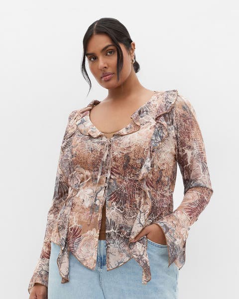 Woman wearing flowy tan printed top.