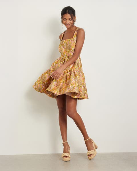 A woman wearing a floral brocade fit-and-flare minidress.