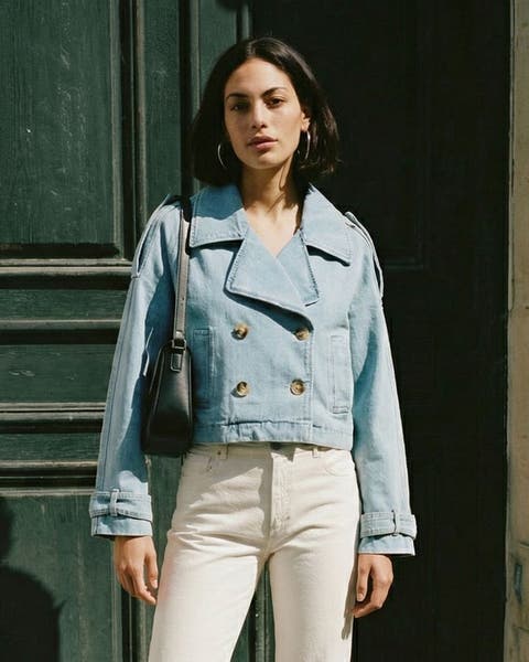 A woman in white jeans and a cropped light denim jacket.