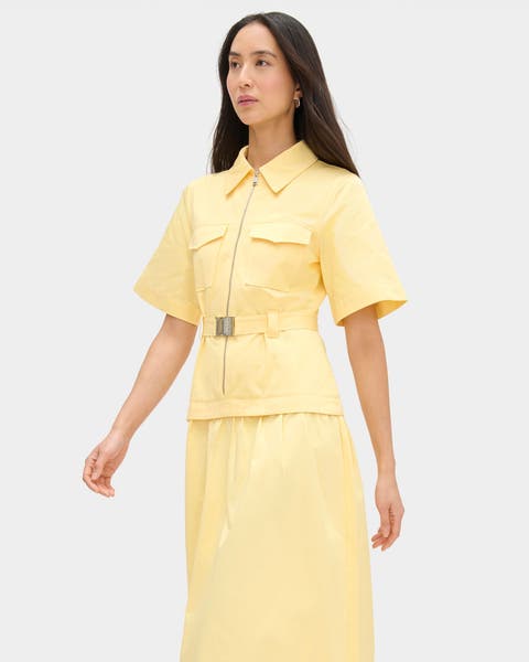 A woman wearing a matching yellow top and midi skirt.