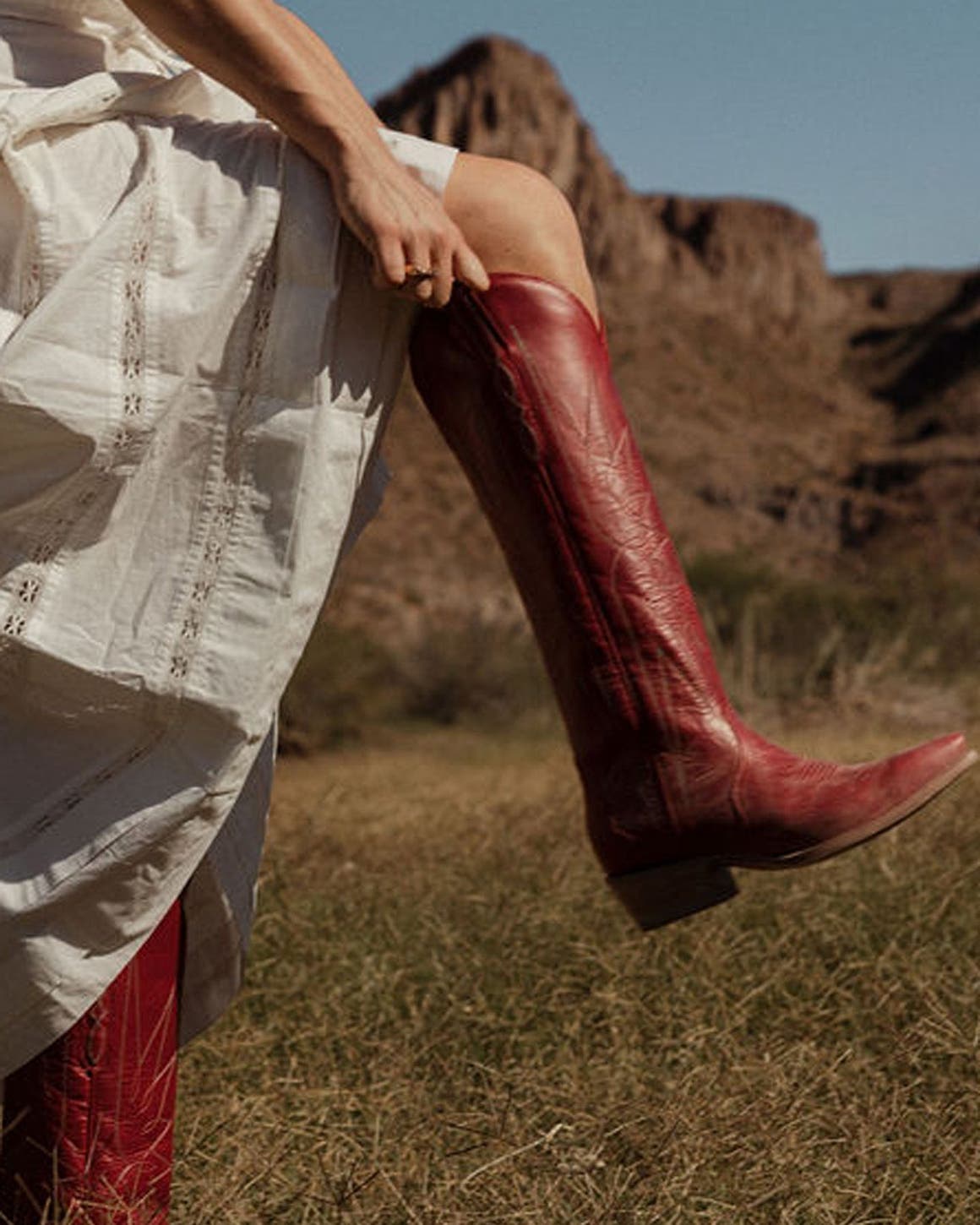 A woman in red knee-high cowboy boots.