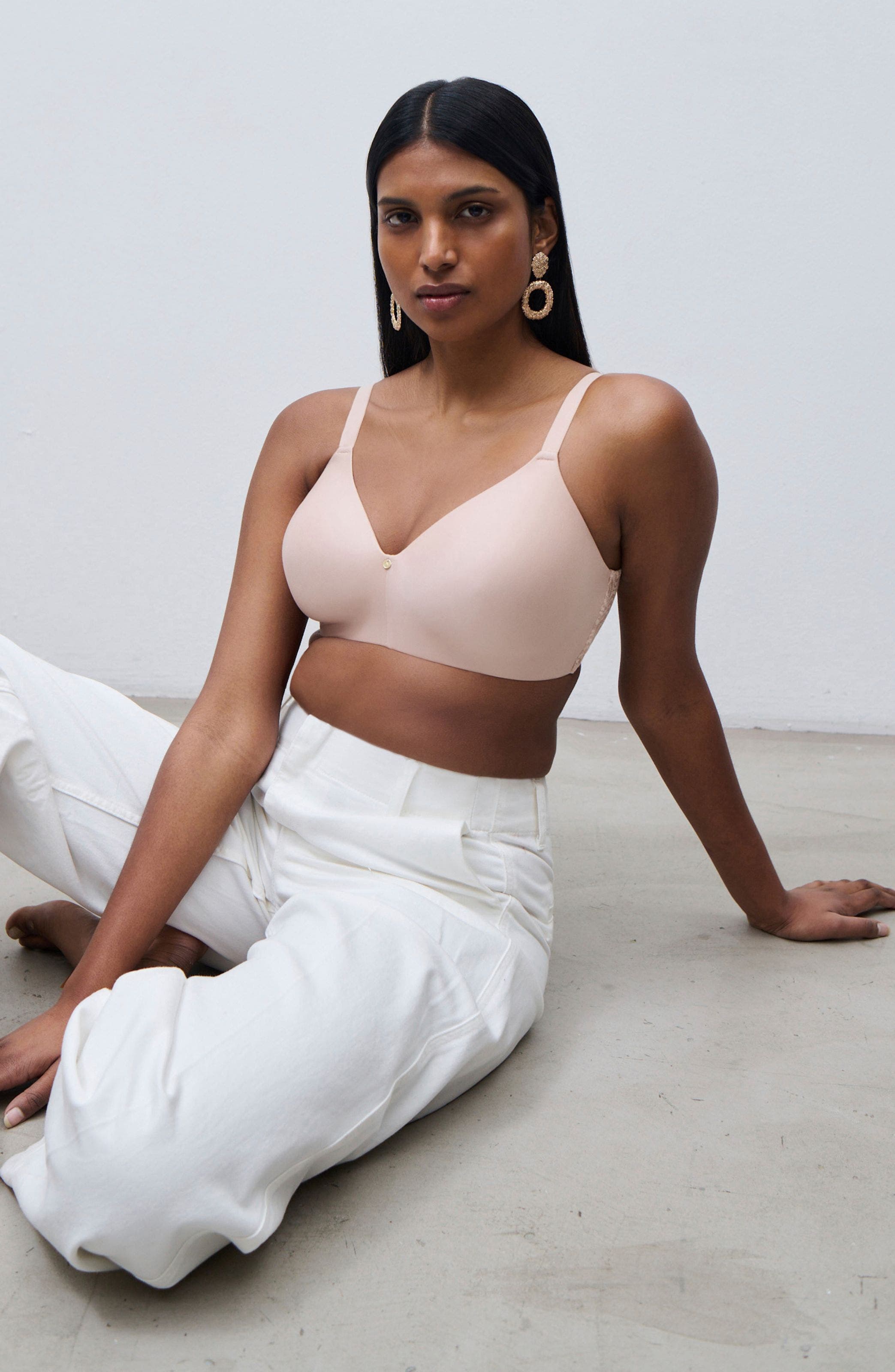 A women wearing white pants and pink bra.