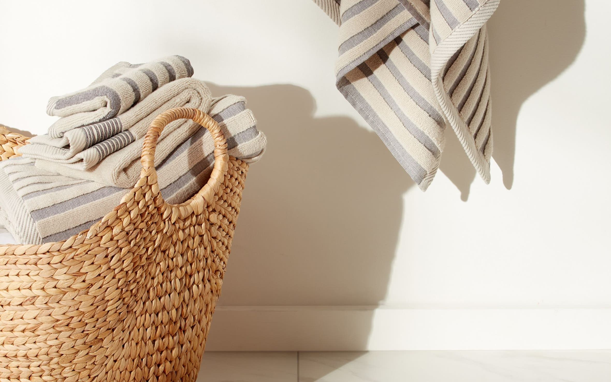 A set of striped towels and a bathmat in neutrals.