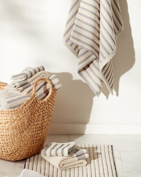 A set of striped towels and a bathmat in neutrals.