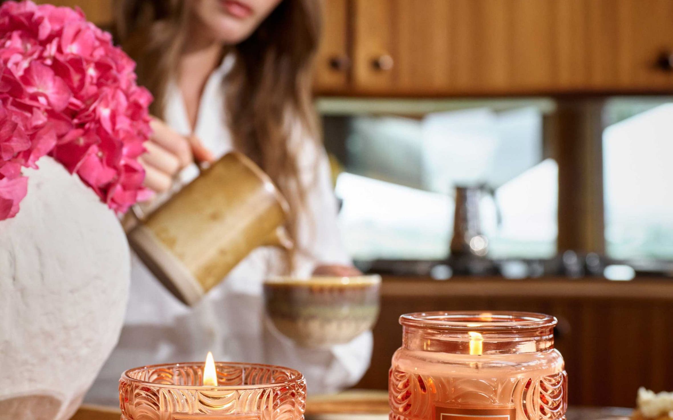 Two Voluspa Spiced Pumpkin Latte candles in orange glass jars.