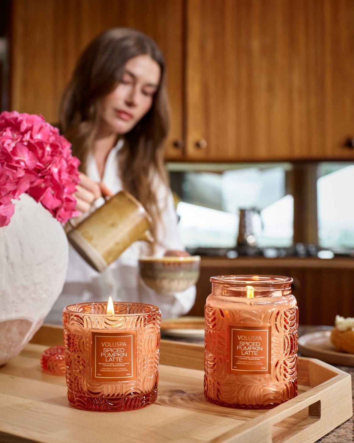 Two Voluspa Spiced Pumpkin Latte candles in orange glass jars.