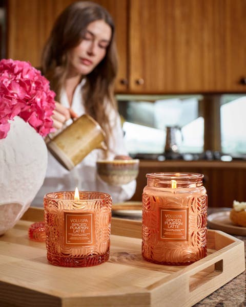Two Voluspa Spiced Pumpkin Latte candles in orange glass jars.