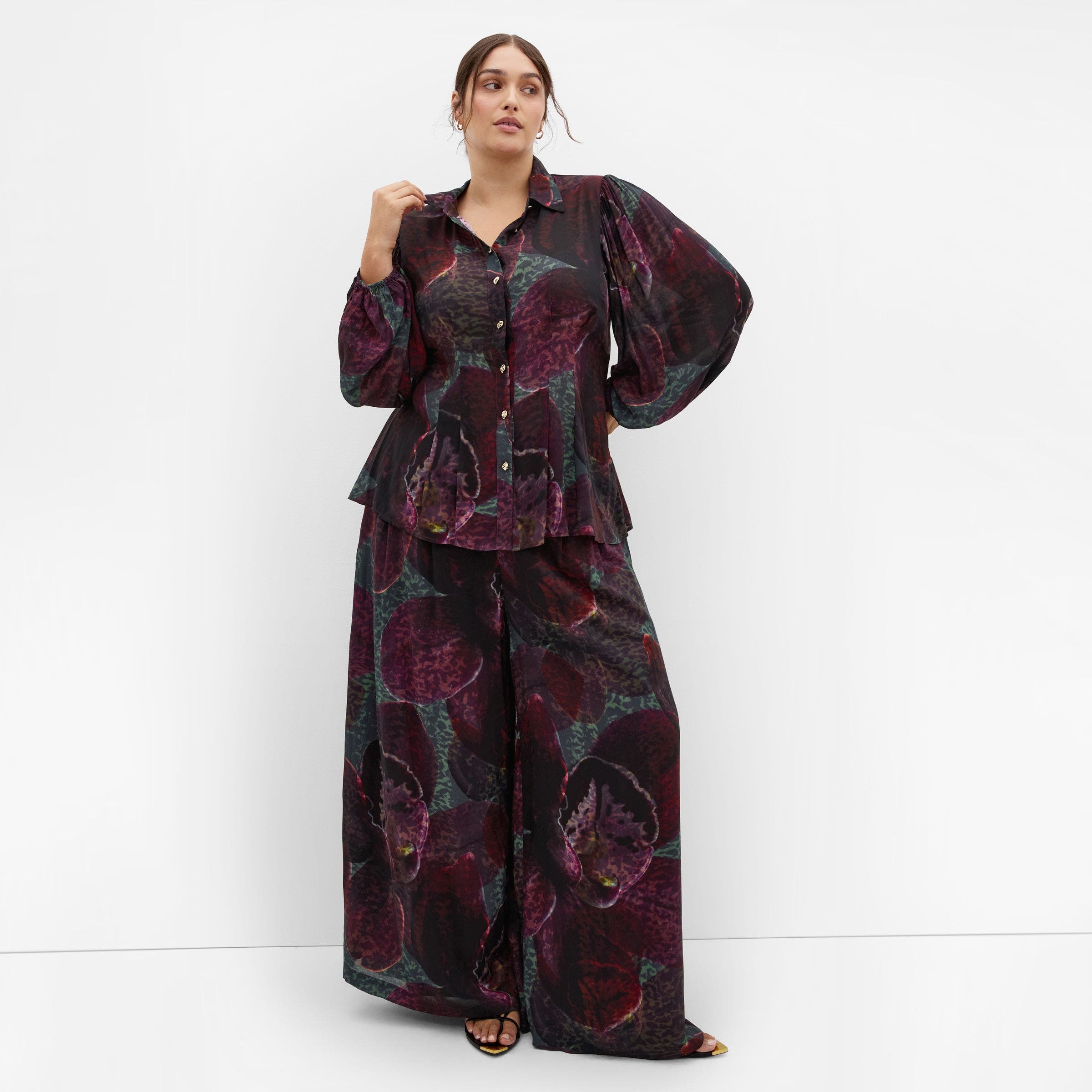 A woman in a floral jacquard blouse.
