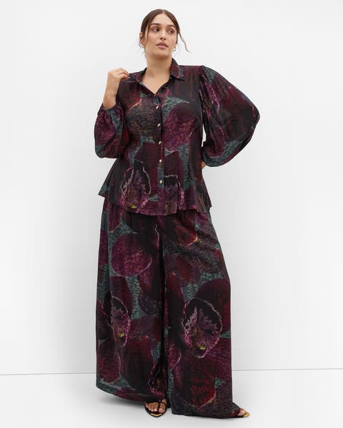 A woman in a floral jacquard blouse.