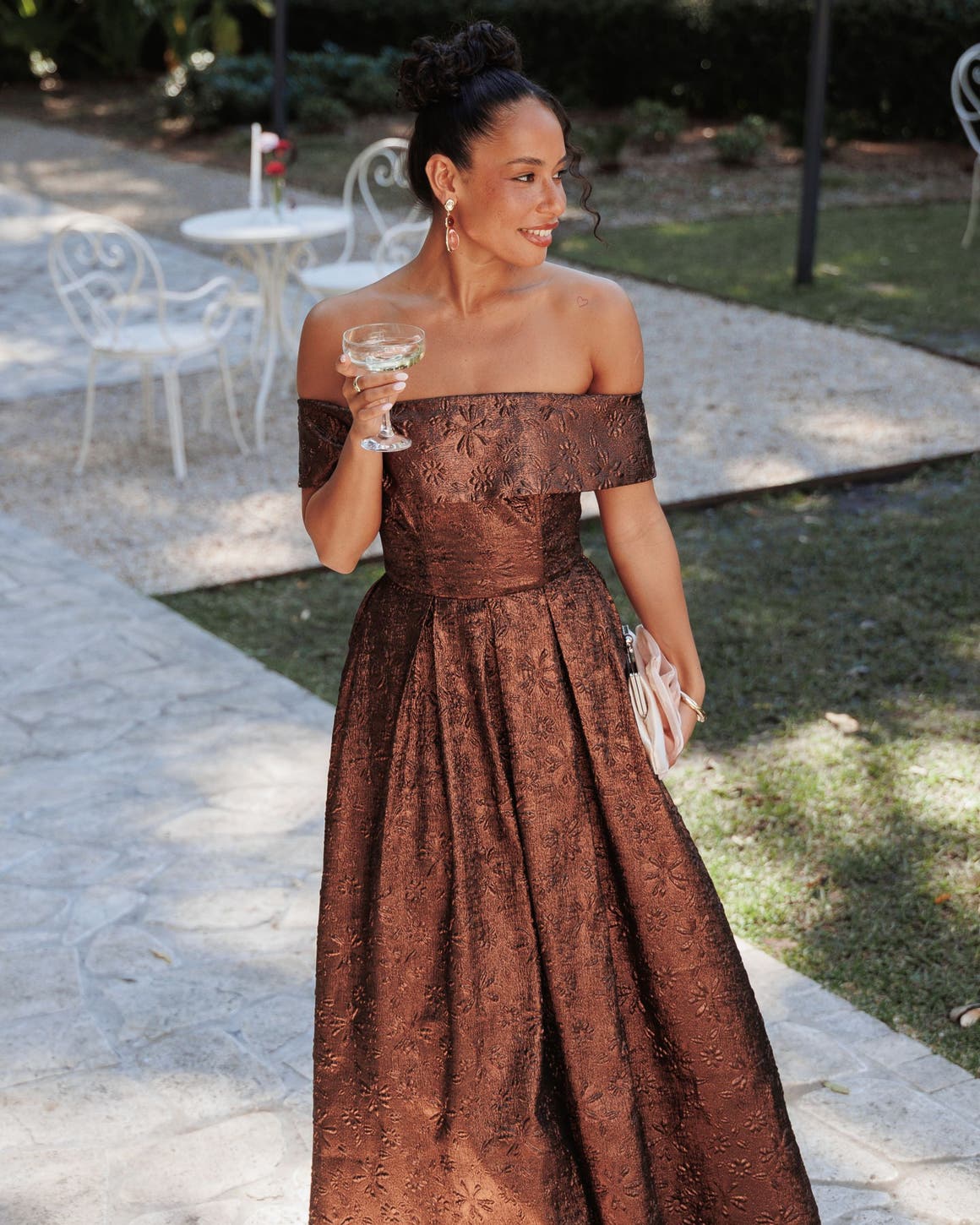 A woman in a bronze off-the-shoulder gown.
