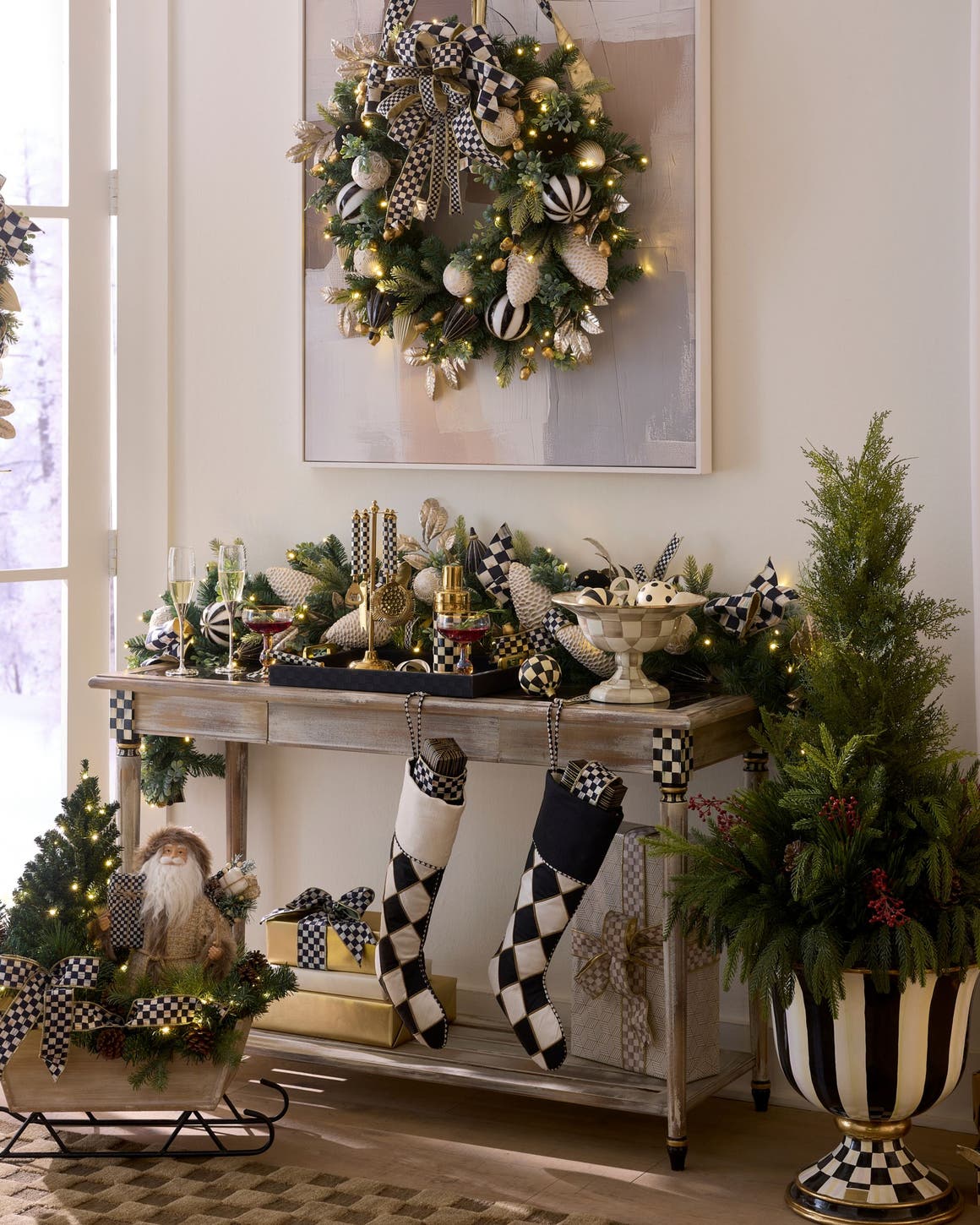 Mackenzie-Childs Courtly Check console table styled with a holiday wreath and black-and-white checkered décor.