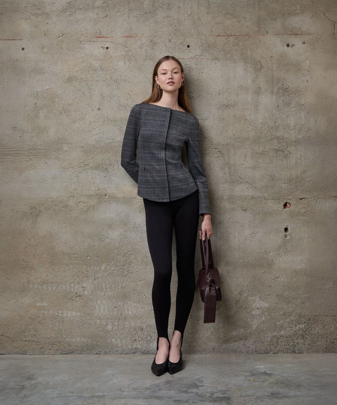 A woman wearing a tailored jacket and black pants.