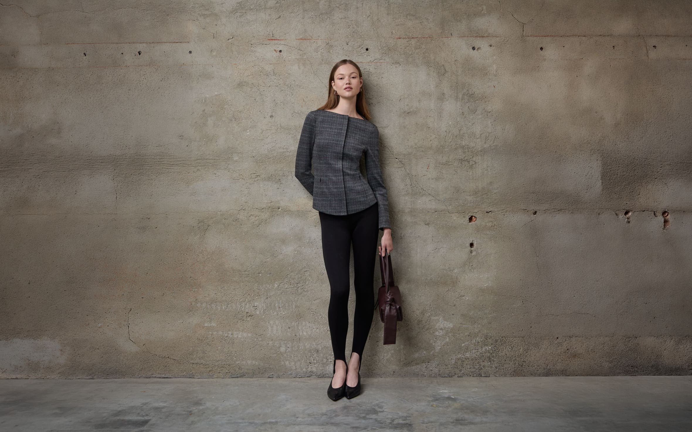 A woman wearing a tailored jacket and black pants.