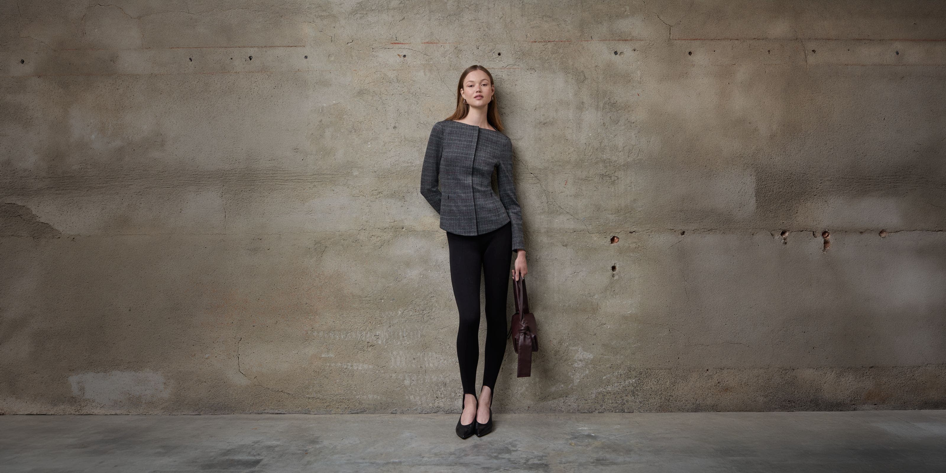 A woman wearing a tailored jacket and black pants.